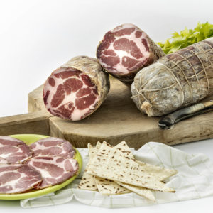 Coppa stagionata di maiale nostrano, prodotta in Gallura, foto su tagliere in legno con spianata