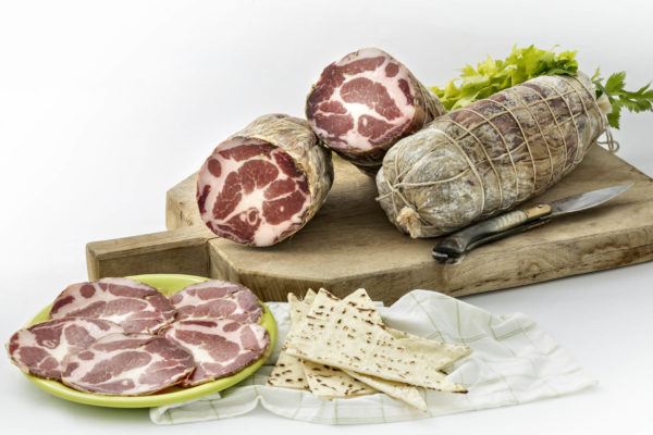 Coppa stagionata di maiale nostrano, prodotta in Gallura, foto su tagliere in legno con spianata