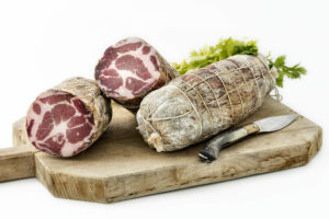 Coppa stagionata di maiale nostrano, prodotta in Gallura, foto su tagliere in legno